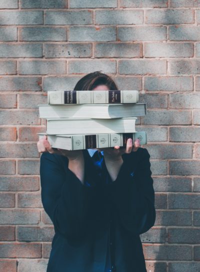 Person with books in front of face